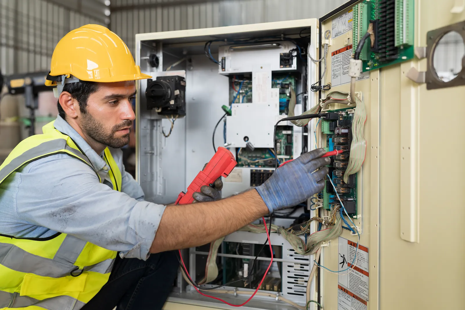 Licensed electrician inspecting electrical panel for maintenance